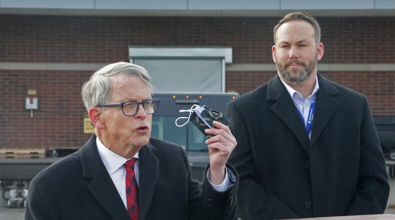 Gov. Mike DeWine reminds residents that they still need to wear a mask Tuesday as Springfield Regional Medical Center President Adam Groshans listens shortly after the first vaccine arrives at the hospital on Tuesday, Dec. 15, 2020. BILL LACKEY/STAFF