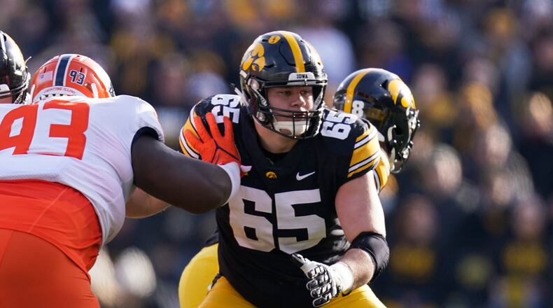 FILE - Iowa offensive lineman Tyler Linderbaum (65) looks to make a block during the first half of an NCAA college football game against Illinois, Nov. 20, 2021, in Iowa City, Iowa. Iowa center Tyler Linderbaum announced Friday, Jan. 14, 2022, he'll skip his senior season and enter the NFL draft. (AP Photo/Charlie Neibergall, File)