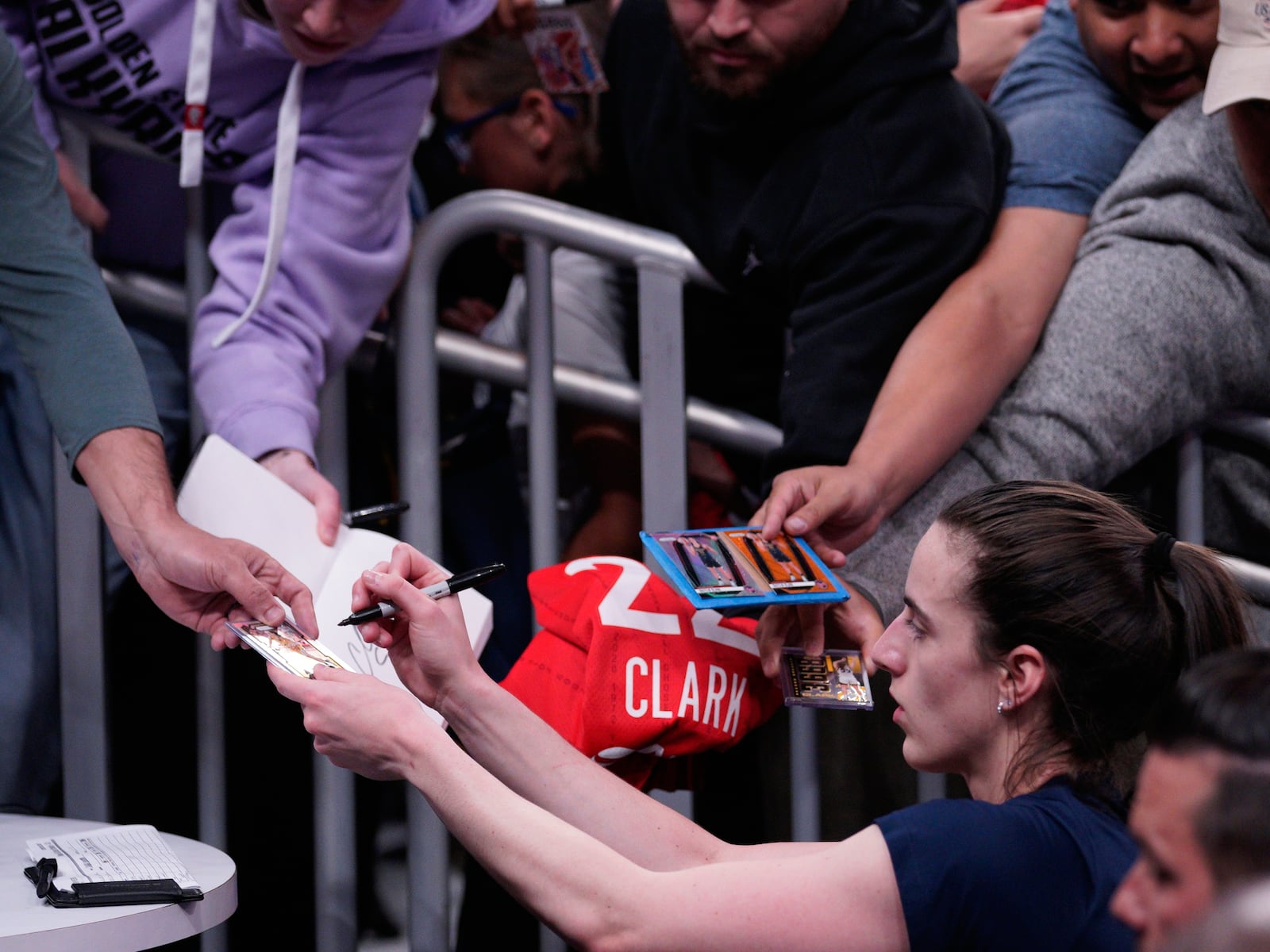 Indiana Fevers guard Caitlin Clark, bottom right, gives autographs before a WNBA basketball game against the Golden State Valkyries in San Francisco, Thursday, June 19, 2025. (Anna Connors/San Francisco Chronicle via AP)