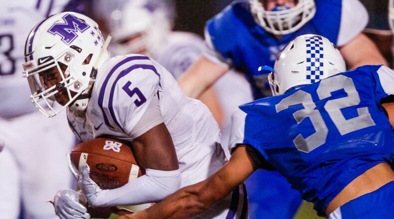 Middletown’s Josh Bryant carries the ball while being defended by Hamilton’s Isaiah Harrison during their Oct. 5 game at Virgil Schwarm Stadium in Hamilton. Host Big Blue won 15-14. NICK GRAHAM/STAFF