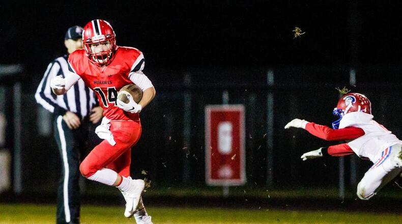 Madison’s Noah Lehman (14) eludes a Portsmouth tackler during last Saturday’s 26-0 victory in a Division V, Region 20 quarterfinal at Brandenburg Field in Madison Township. NICK GRAHAM/STAFF