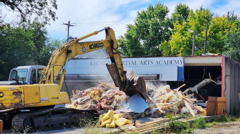 The former Legacy Martial Arts Academy on Main Street began to be razed in Hamilton on Tuesday, making way for a new 23,245-square-foot standalone parking. The 52-space lot, which will include two EV charging stations, will be adjacent to the planned Agave & Rye restaurant. There will be some type of parking enforcement of the lot ― which could be with signs and traffic enforcement monitoring, meters, or a parking kiosk ― and limits wouldn’t be longer than a few hours, city officials said. The Agave & Rye project is expected to begin once the parking lot construction is complete. NICK GRAHAM/STAFF