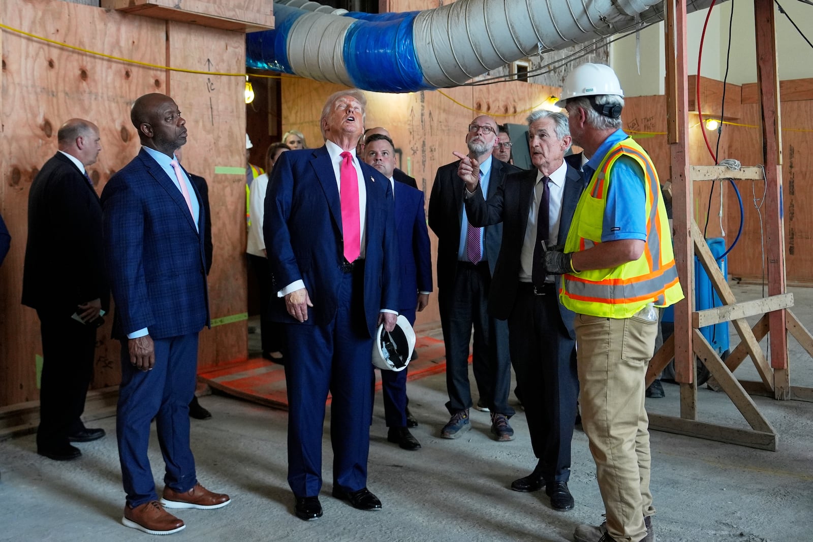 Sen. Tim Scott, R-S.C., from foreground left, President Donald Trump and Federal Reserve Chairman Jerome Powell visit the Federal Reserve, joined by Russell Vought, director of the Office of Management and Budget, in background third from right, Thursday, July 24, 2025, in Washington. (AP Photo/Julia Demaree Nikhinson)
