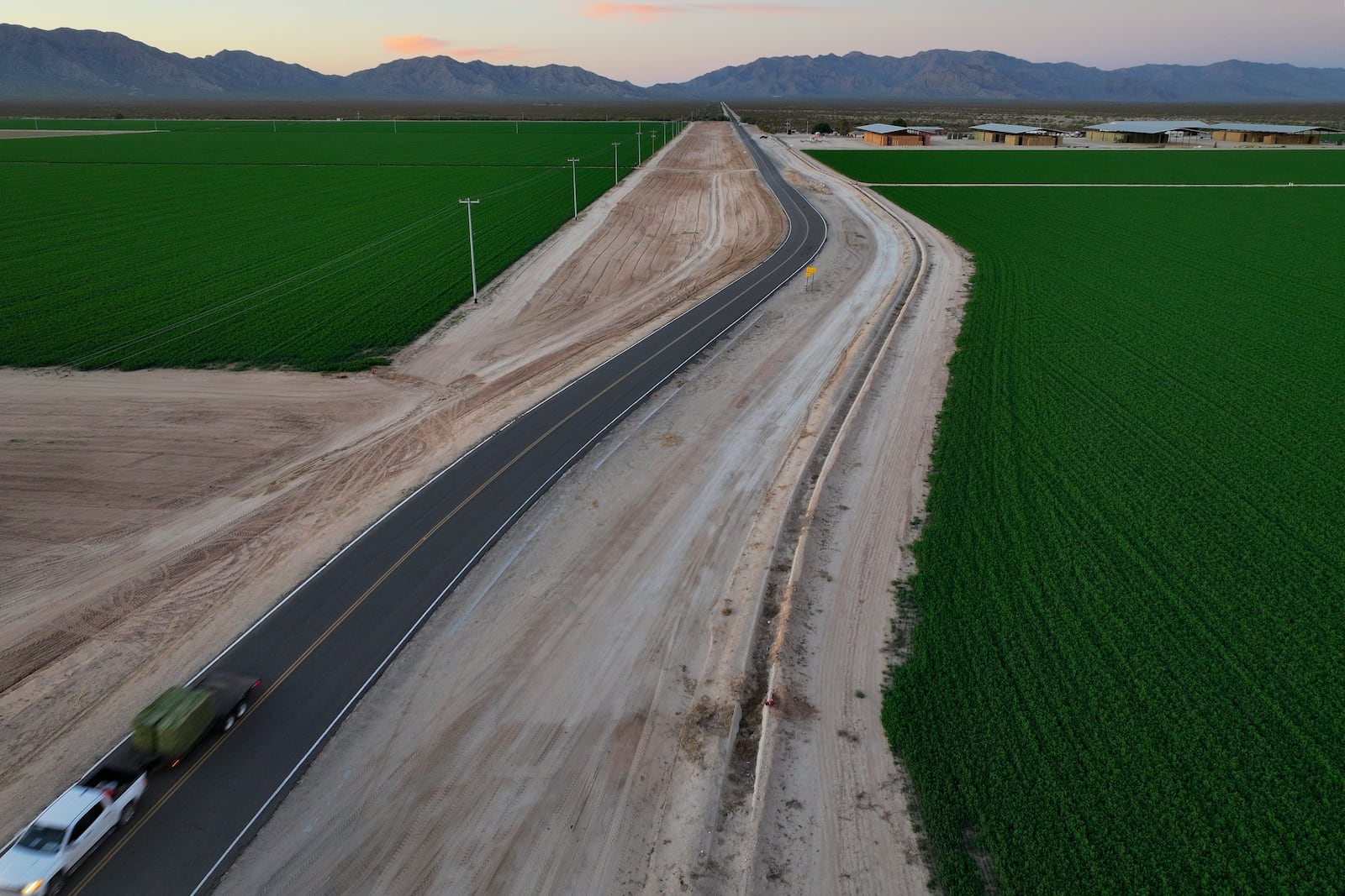FILE - A truck hauling hay drives near Al Dahra Farms, Tuesday, Oct. 17, 2023, in the McMullen Valley in Wenden, Ariz. (AP Photo/John Locher, File)