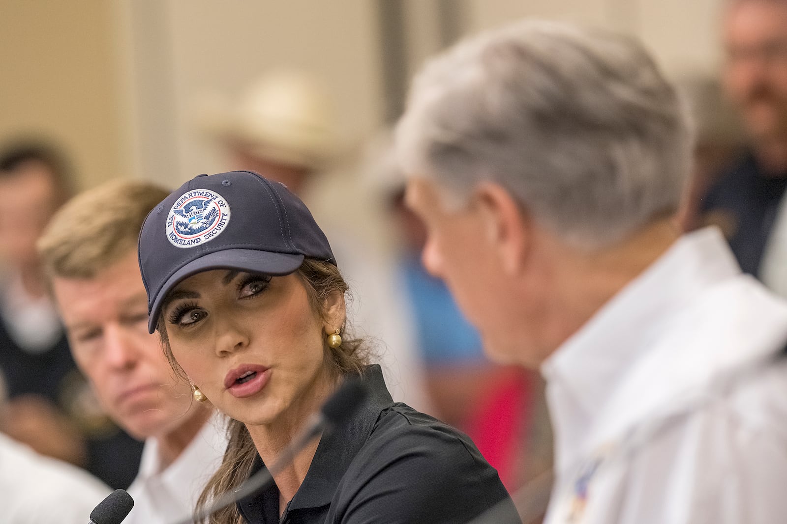 Homeland Security Secretary Kristi Noem, center, speaks with Texas Gov. Greg Abbott, right, about ongoing search and rescue efforts after recent flooding along the Guadalupe River during a press conference on Saturday, July 5, 2025, in Ingram, Texas. (AP Photo/Rodolfo Gonzalez)