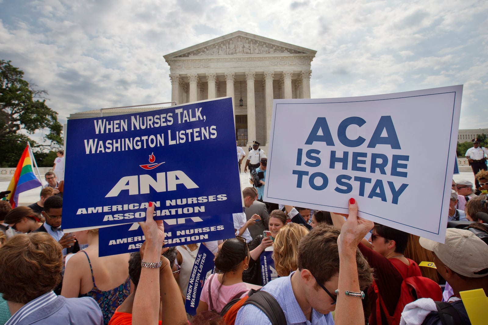 FILE - Supporters of the Affordable Care Act hold up signs as the opinion for health care is reported outside of the Supreme Court in Washington, June 25, 2015. The Supreme Court on Thursday upheld the nationwide tax subsidies under President Barack Obama's health care overhaul, in a ruling that preserves health insurance for millions of Americans. (AP Photo/Jacquelyn Martin, File)