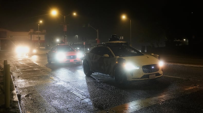 A Waymo vehicle sits idling at an intersection with no operating traffic lights due to power outages, in San Francisco, Saturday, Dec. 20, 2025. (AP Photo/Jeff Chiu)