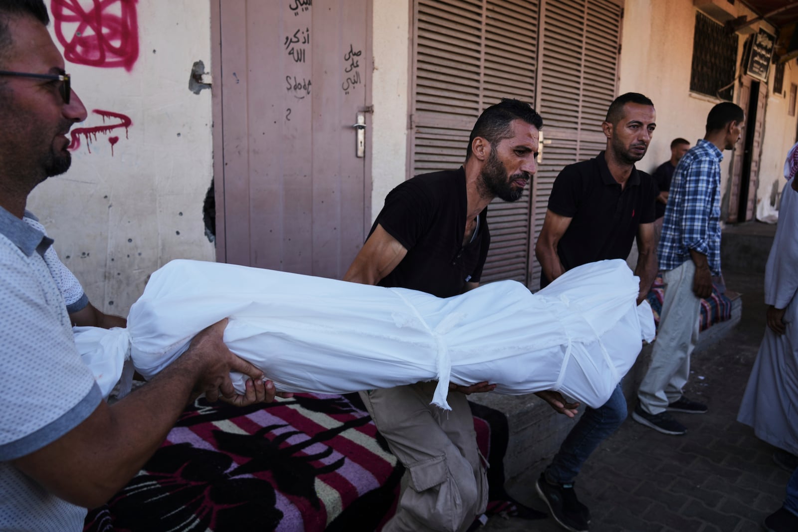 Mourners carry the body Ibrahim Al-Khatib who was killed in an Israeli bombardment of Al-Zawaideh, central Gaza Strip, Thursday, July 24, 2025. (AP Photo/Abdel Kareem Hana)