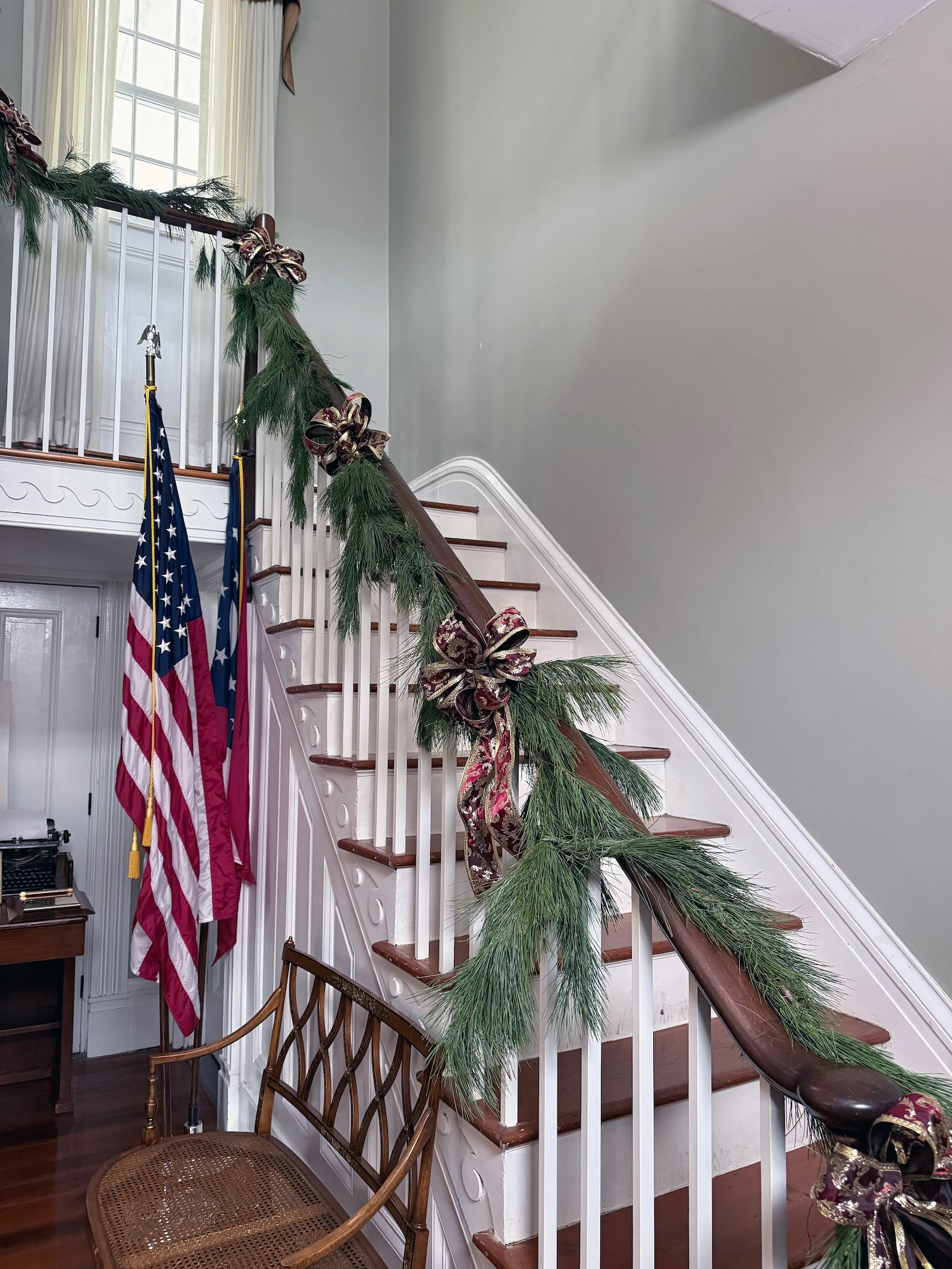 The staircase in the Elisha Morgan mansion in Fairfield's Gilbert Park is decorated for Christmas with burgundy and gold ribbons mixed with greens as it would have when the home was built. FOUR SEASONS GARDEN CLUB/CONTRIBUTED