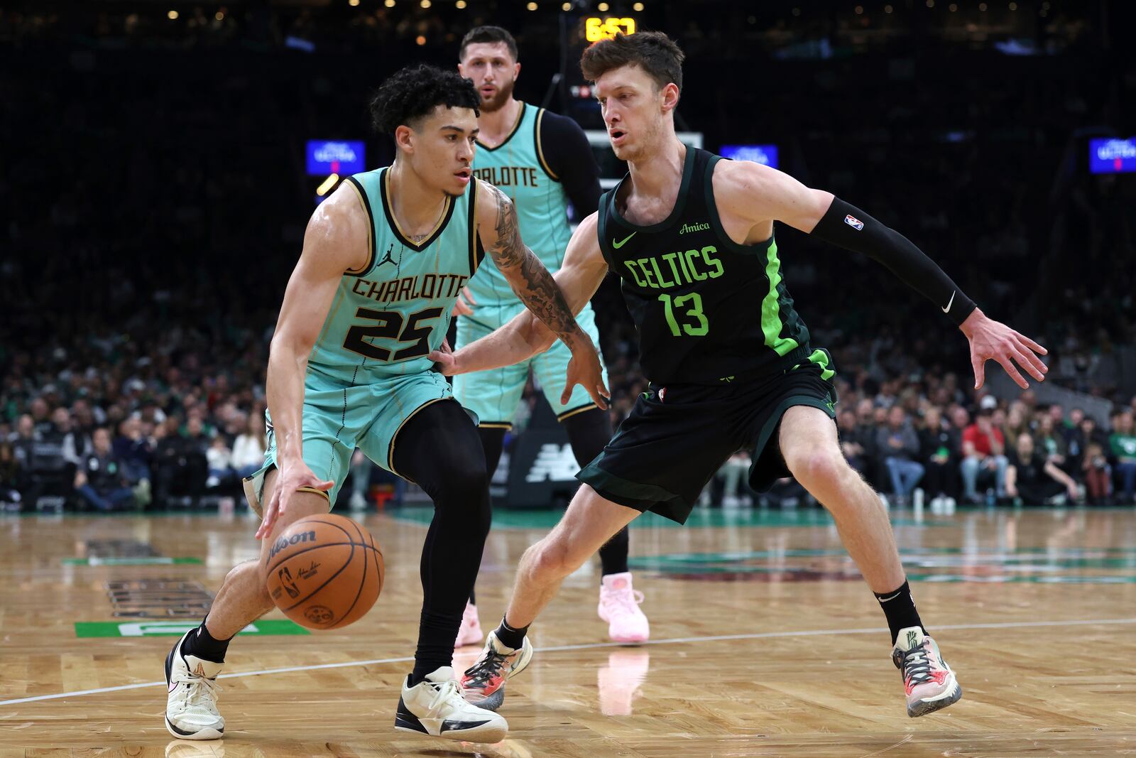 Charlotte Hornets' KJ Simpson (25) drives past Boston Celtics' Drew Peterson (13) during the first half of an NBA basketball game Sunday, April 13, 2025, in Boston. (AP Photo/Michael Dwyer)