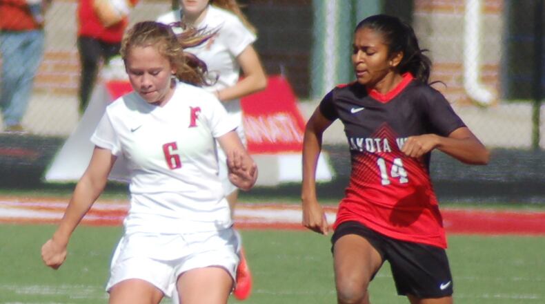 Lily Welch plays the ball up the field for Fairfield as Divya Patel applies pressure for Lakota West during their Division I sectional semifinal last Saturday at Fairfield. CONTRIBUTED PHOTO BY JOHN CUMMINGS