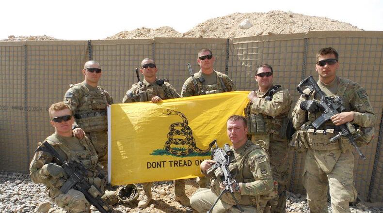 Members of the 1st Platoon James O. Twist, Reyler Leon, Joe Morrissey, Andy Lehrer, Mike McGuinness, Dallas Haggard (kneeling) and Brandon Krebs pose with a flag in Afghanistan in 2012. SUBMITTED PHOTO