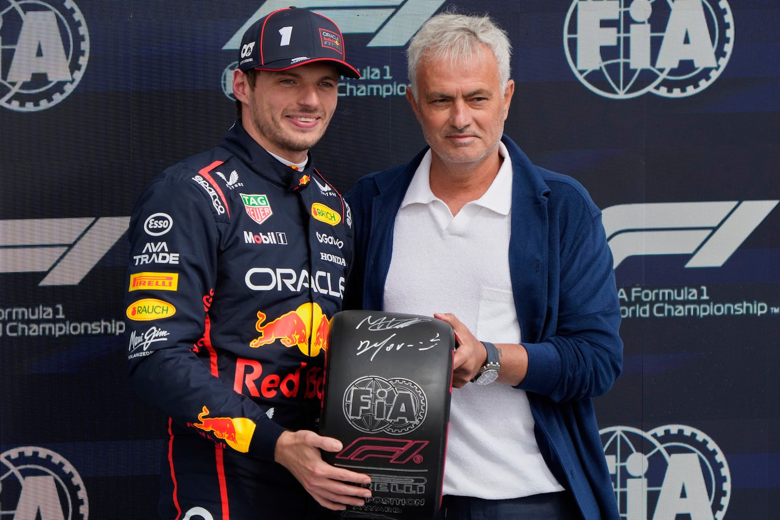 Red Bull driver Max Verstappen of the Netherlands and a soccer coach Jose Mourinho pose after the qualifying for the British Formula One Grand Prix in Silverstone, England, Saturday, July 5, 2025. (AP Photo/Darko Bandic)