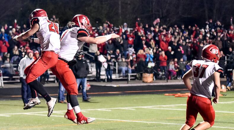 Madison’s Cameron Svarda (left) jumps up to celebrate his touchdown with Mason Whiteman as Tanner Limon (36) runs back on the field during their Division V regional final against West Jefferson on Nov. 17, 2017, at Beavercreek. Madison won 42-7. NICK GRAHAM/STAFF