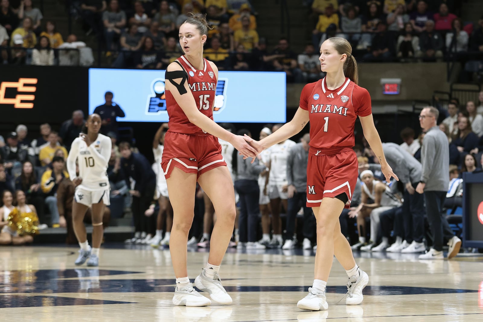 Miami (Ohio) forward Amber Tretter (15) and guard Amber Scalia (1) celebrate in the first half against West Virginia in the first round of the NCAA college basketball tournament, Saturday, March 21, 2026, in Morgantown, W.Va. (AP Photo/Kathleen Batten)