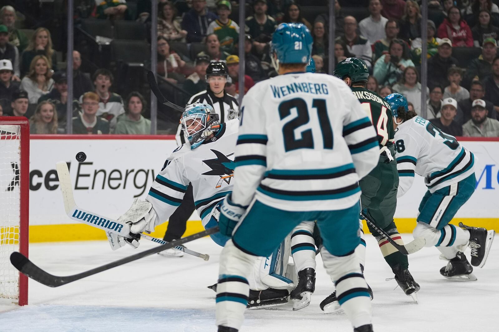 San Jose Sharks goaltender Alexandar Georgiev (40), back, left, defends against a shot during the first period of an NHL hockey game against the Minnesota Wild, Wednesday, April 9, 2025, in St. Paul, Minn. (AP Photo/Abbie Parr)