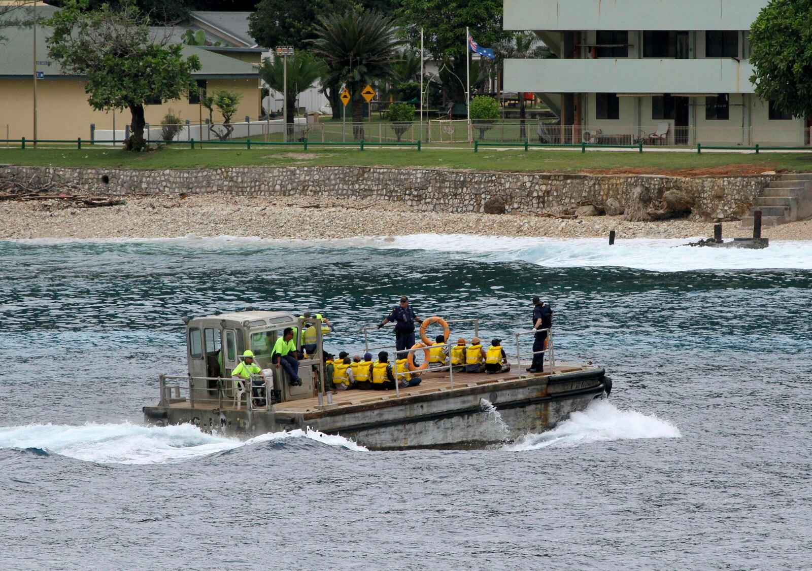 FILE - A group of Vietnamese asylum seekers are taken by barge to a jetty on Australia's Christmas Island on April 14, 2013. (AP Photo, File)