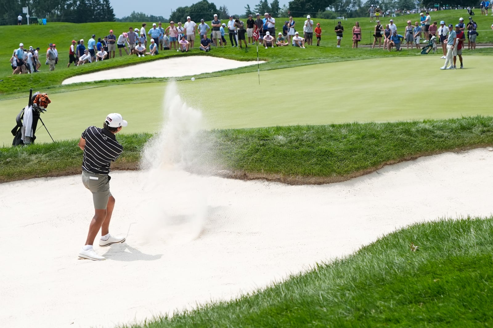 FILE - Charlie Woods hits onto the 17th green during the first round of stroke play of the U.S. Junior Amateur Golf Championship, in Bloomfield Township, Mich., July 22, 2024. (AP Photo/Carlos Osorio, File)