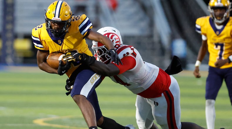 Springfield's Tre Montgomery is tackled by Trotwood's Jamarcus Whyce. BILL LACKEY/STAFF