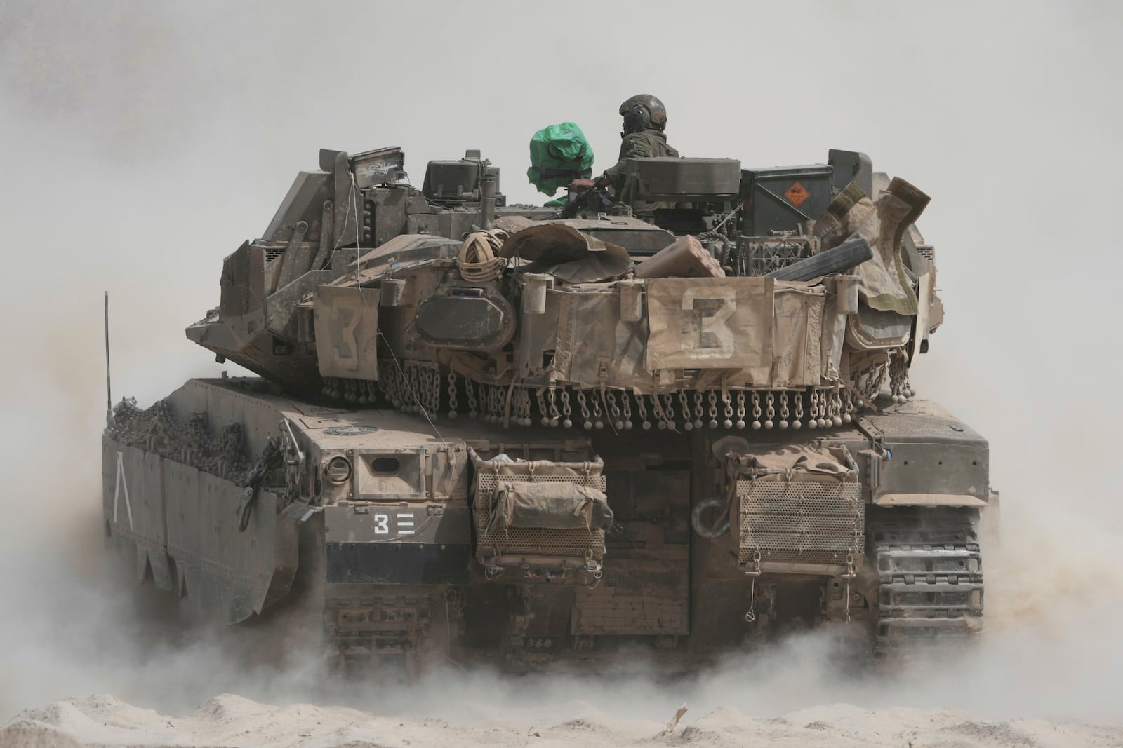 Israeli soldiers move tanks around staging area near the border with the Gaza Strip, in southern Israel, Sunday, May 18, 2025. (AP Photo/Ariel Schalit)