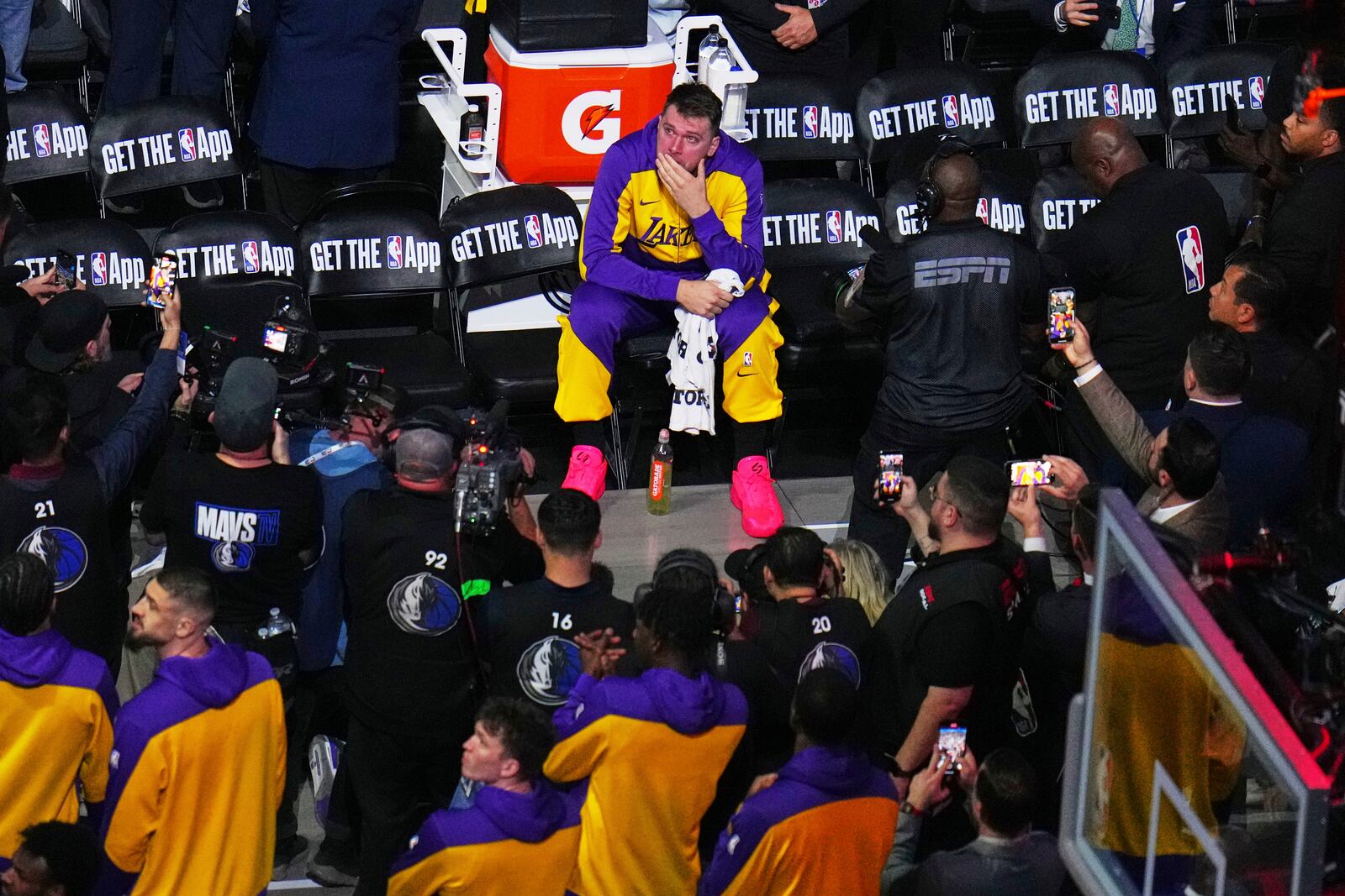 Los Angeles Lakers' Luka Doncic looks up at a large video board paying a tribute to the former Dallas Mavericks player before an NBA basketball game in Dallas, Wednesday, April 9, 2025. (AP Photo/Julio Cortez)