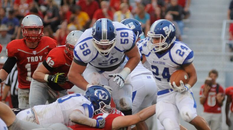 OSU recruit Josh Myers (58) overcame an early ankle injury and helps pave the way for running back Tony Clark. Miamisburg defeated Troy 21-17 in a Week 5 high school football GWOC crossover game at Troy’s Memorial Stadium on Friday, Sept. 23, 2016. MARC PENDLETON / STAFF