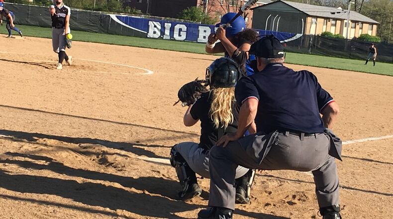 Middletown’s Carly Metcalf sends a pitch toward her catcher, Katie Pearson, and Hamilton’s Mya Halcomb (23) during Monday’s Greater Miami Conference game at HHS. RICK CASSANO/STAFF