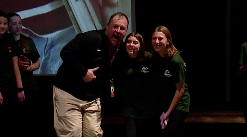 Social studies teacher Kristopher Hensley smiles with two students after they selected him as their positive role model at an assembly on Feb. 5, 2025. MARC PRICE/WCPO