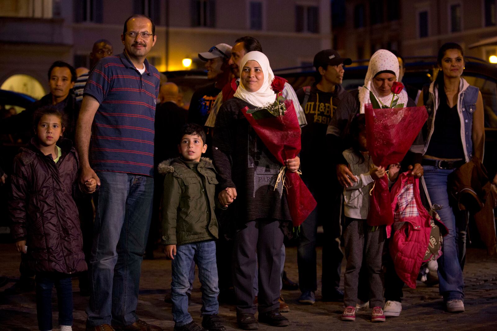 FILE - Syrian refugees Wafa, no last name available, and her husband, Osama, hold their children's hands as they arrive with another Syrian family at the St. Egidio Community in Rome, April 16, 2016. (AP Photo/Alessandra Tarantino, File)