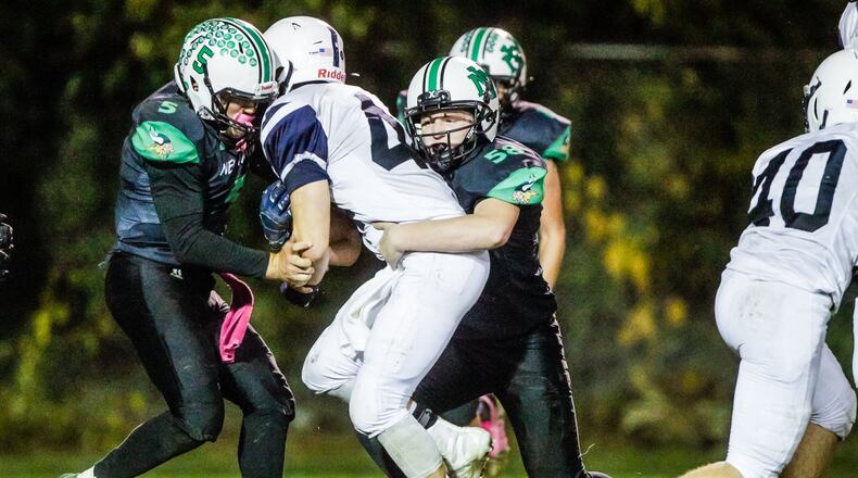 New Miami’s Trey Robinette (5) and Tug Jones (58) tackle Cincinnati Country Day’s Keane Warner during their football game Friday, Oct. 25, 2019 at New Miami High School. New Miami defeated Cincinnati Country Day 34-6 and is 9-0 for the first time in school history. NICK GRAHAM/STAFF