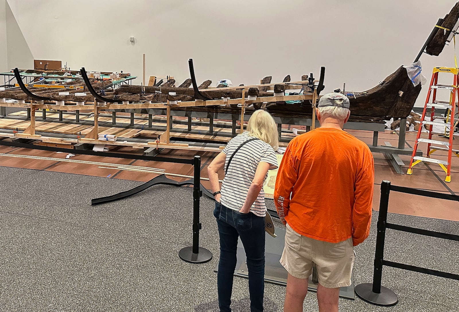 Visitors to the New York State Museum view a Revolutionary War-era gunboat that is being partially reconstructed, Friday, May 30, 2025, in Albany, New York. (AP Photo/Michael Hill)