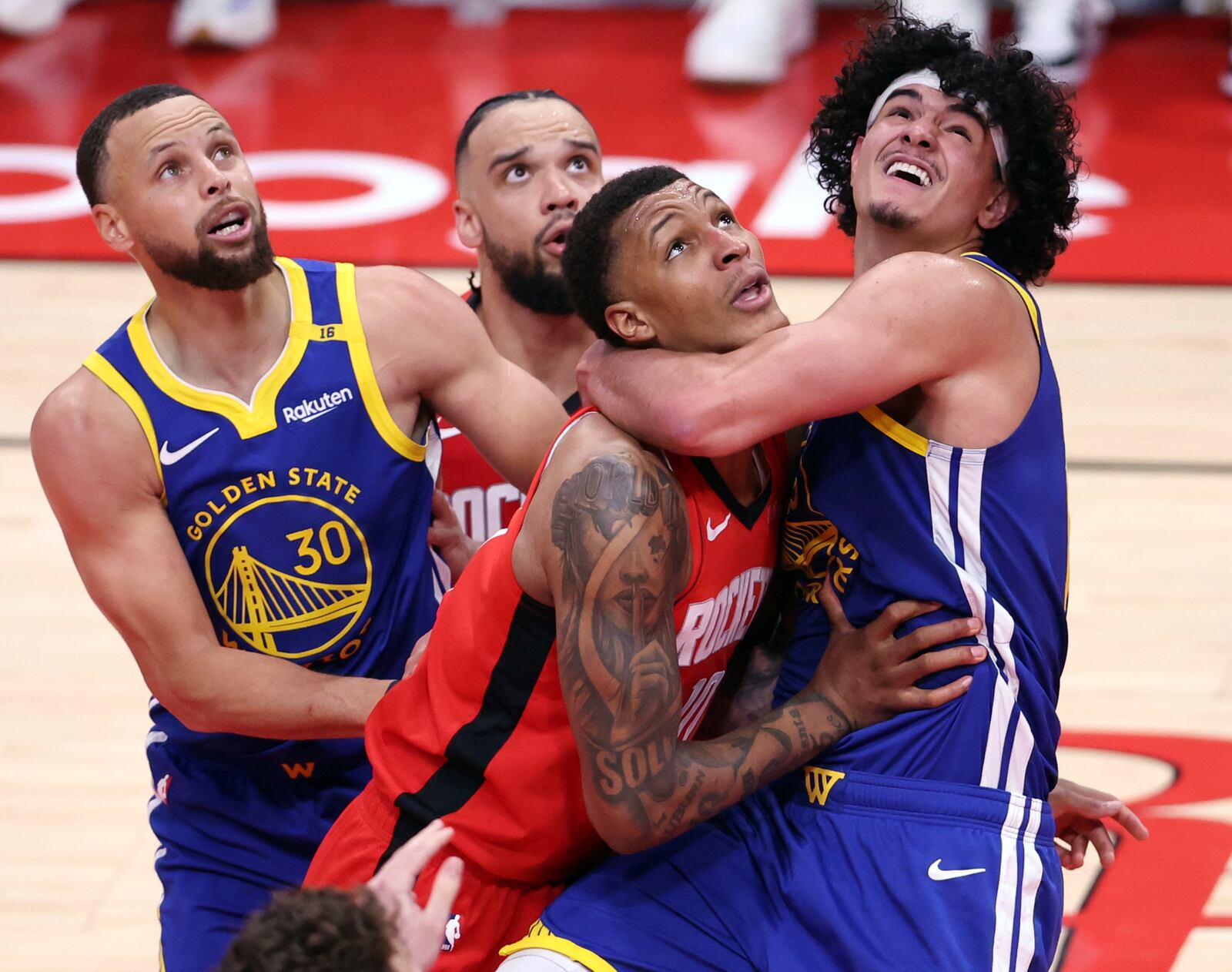 Golden State Warriors' Gui Santos, right, and Houston Rockets' Jabari Smith, Jr., front, vie for rebound position during the first half of Game 1 of an NBA basketball first-round playoff series in Houston, Sunday, April 20, 2025. (Scott Strazzante/San Francisco Chronicle via AP)