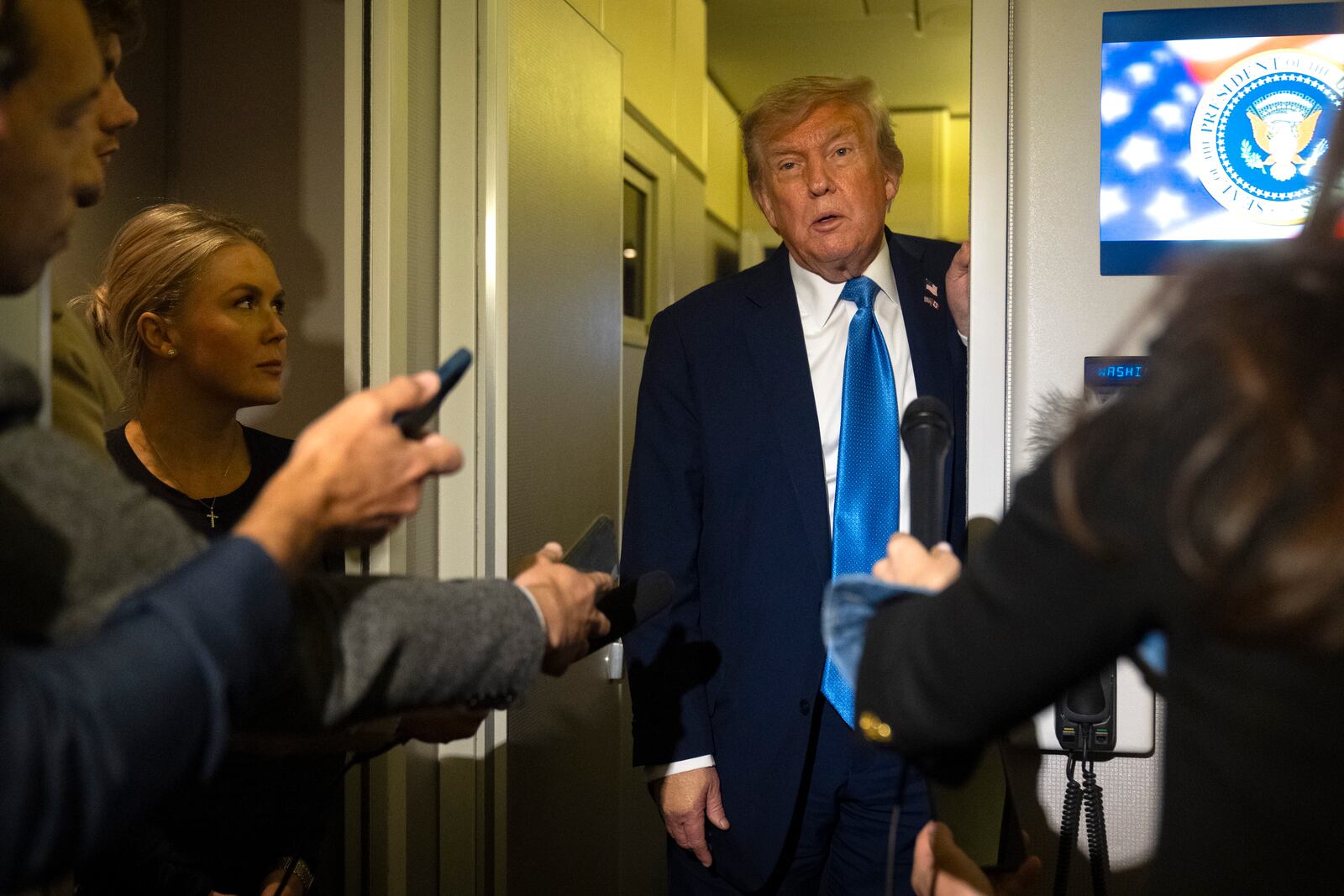 President Donald Trump speaks with reporters as White House press secretary Karoline Leavitt listens while flying aboard Air Force One en route from Calgary, Canada to Joint Base Andrews, Md., late Monday, June 16, 2025. (AP Photo/Mark Schiefelbein)