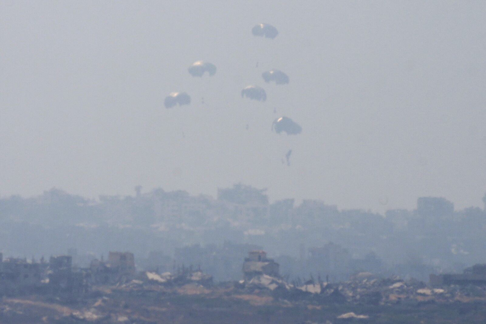 Humanitarian aid is airdropped to Palestinians over Gaza City, as seen from southern Israel, Sunday, July 27, 2025. (AP Photo/Ohad Zwigenberg)