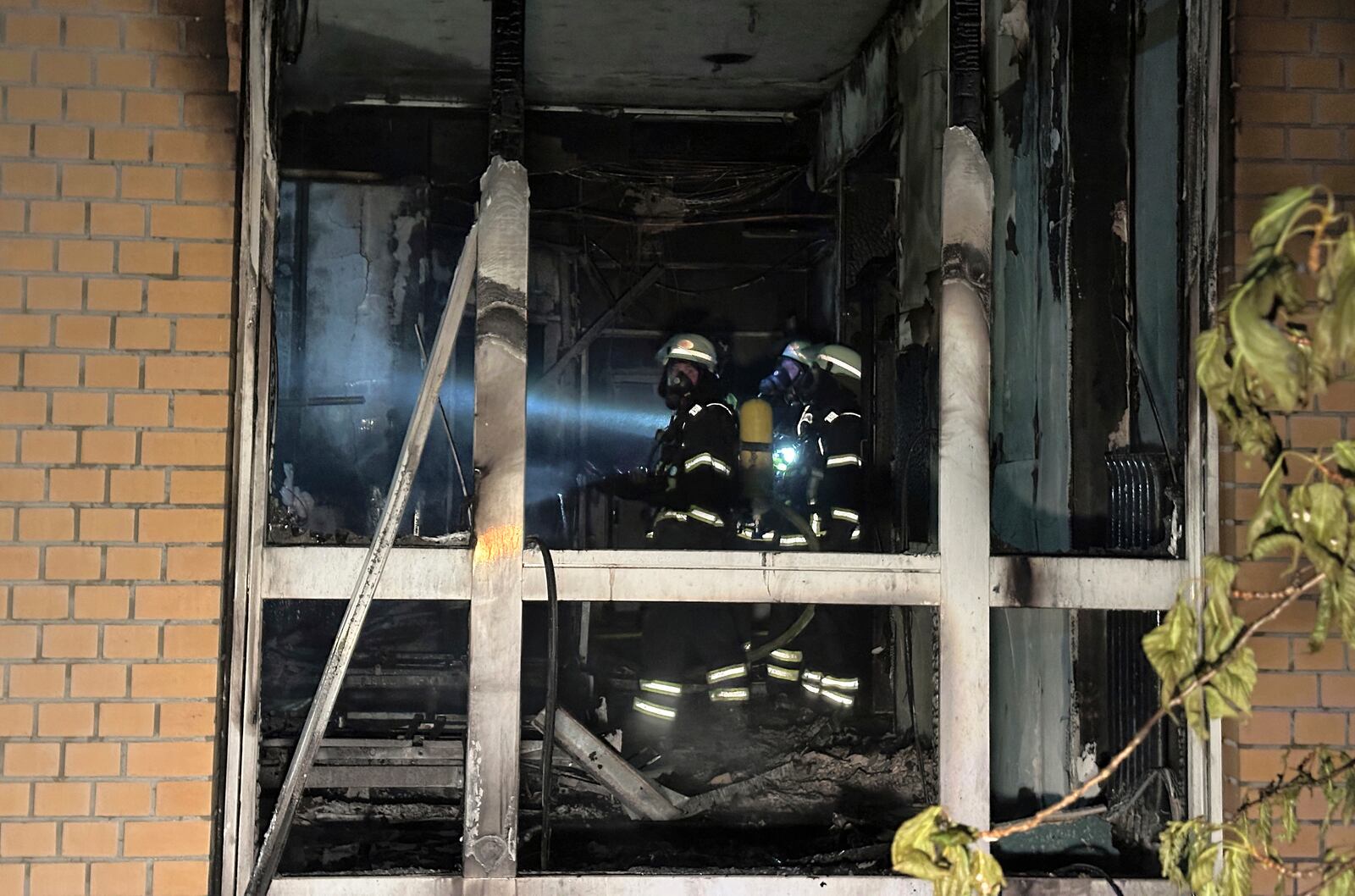 Firefighters wearing breathing apparatus work in a burnt-out room on the ground floor of the Marienkrankenhaus hospital in the Hohenfelde district of Hamburg, Germany Sunday, June 1, 2025. (Steven Hutchings/dpa via AP)