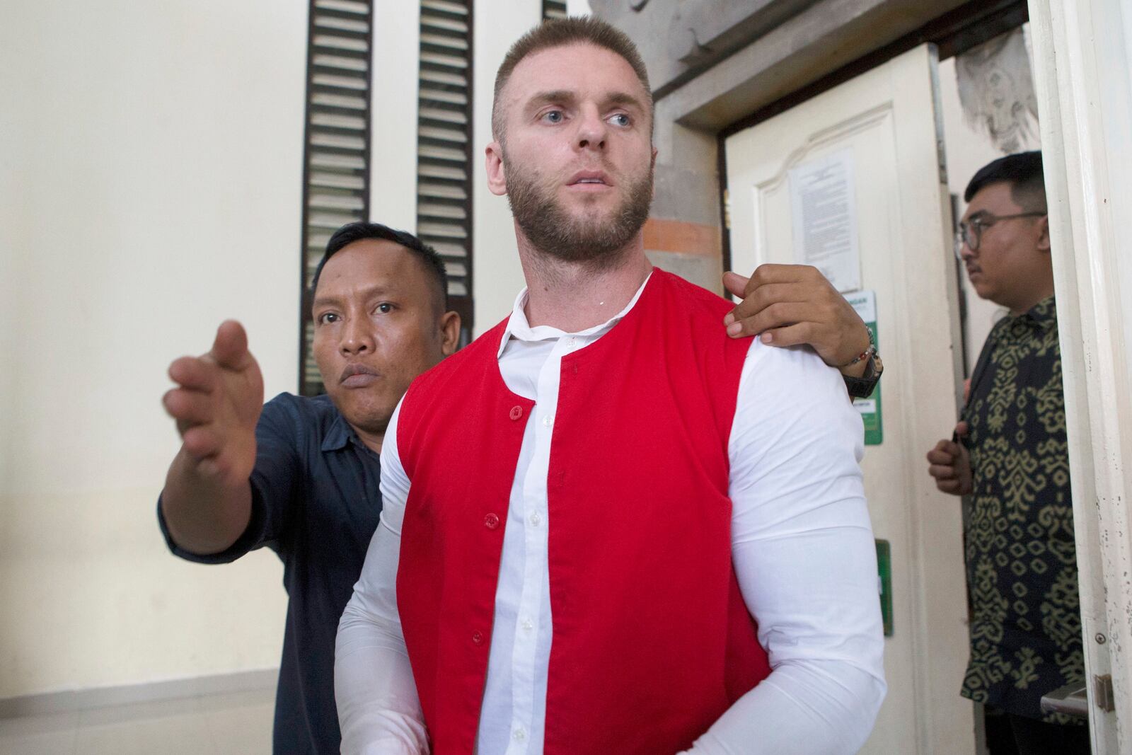 British citizen Thomas Parker, center, who is accused of drug offenses walks to a holding cell after his trial hearing at a district court in Denpasar, Bali, Indonesia, Tuesday, May 20, 2025. (AP Photo/Firdia Lisnawati)
