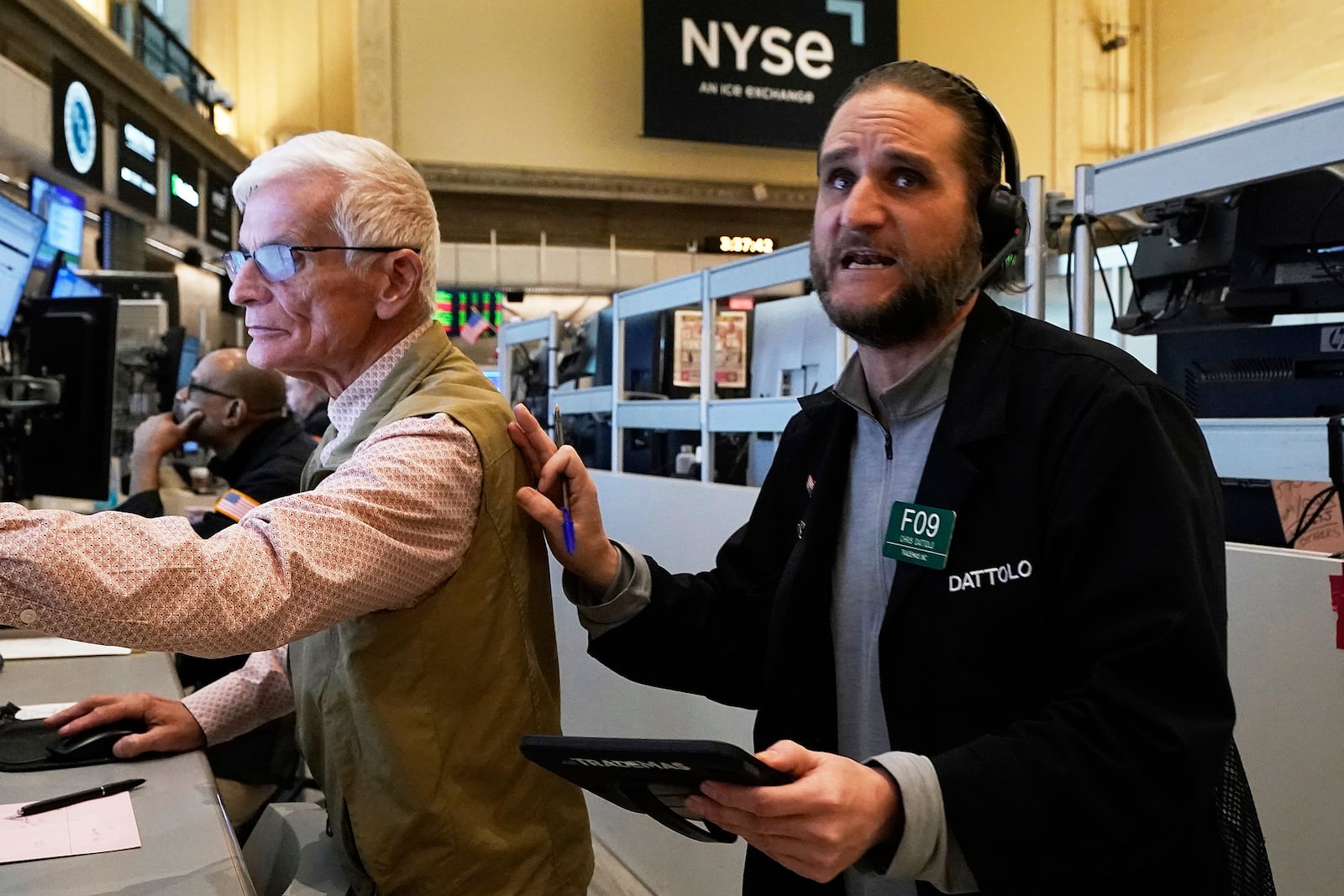 Options trader Chris Dattollo, right, works on the floor of the New York Stock Exchange, Monday, May 12, 2025. (AP Photo/Richard Drew)