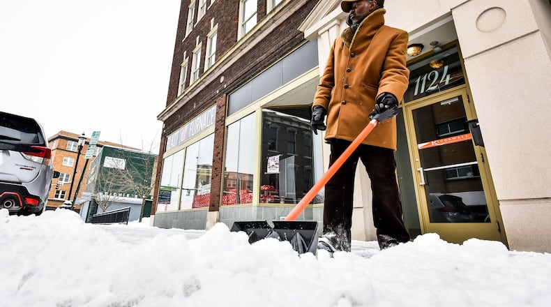 Sterling Jackson shovels snow in front of businesses along Central Avenue Friday morning, Feb. 1, 2019 in Middletown. NICK GRAHAM/STAFF