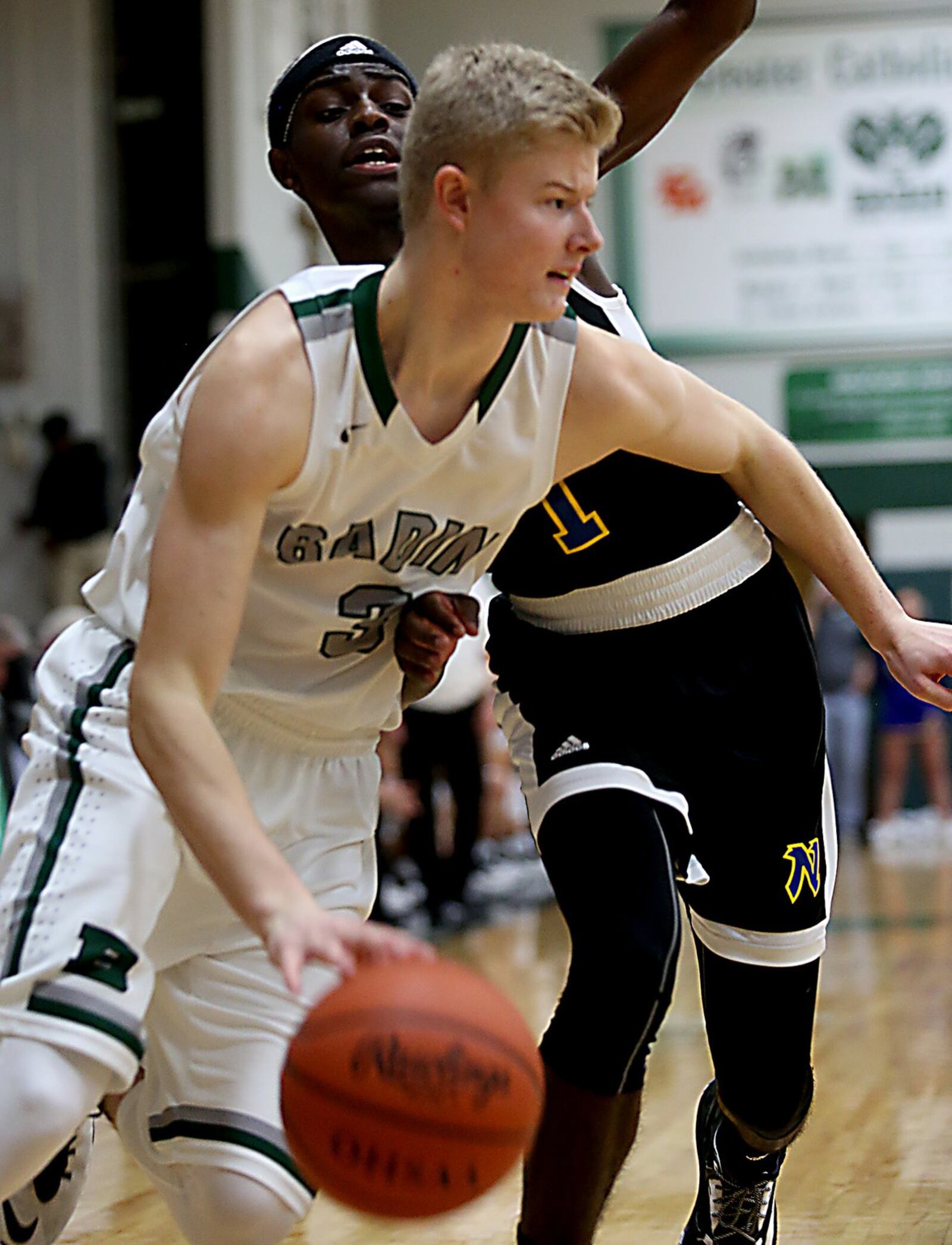 Badin wing Seth Thompson is covered by Northwest guard Jacob Collins during Wednesday night’s game at Mulcahey Gym in Hamilton. CONTRIBUTED PHOTO BY E.L. HUBBARD