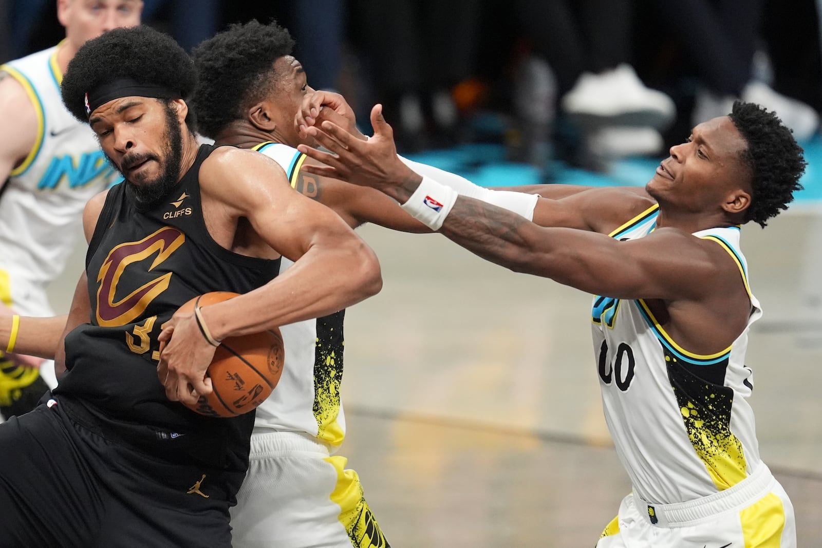 Cleveland Cavaliers center Jarrett Allen (31) takes the ball from Indiana Pacers center Thomas Bryant, second from left, and guard Bennedict Mathurin (00) during the second half of Game 3 in the Eastern Conference semifinals of the NBA basketball playoffs in Indianapolis, Friday, May 9, 2025. (AP Photo/Michael Conroy)