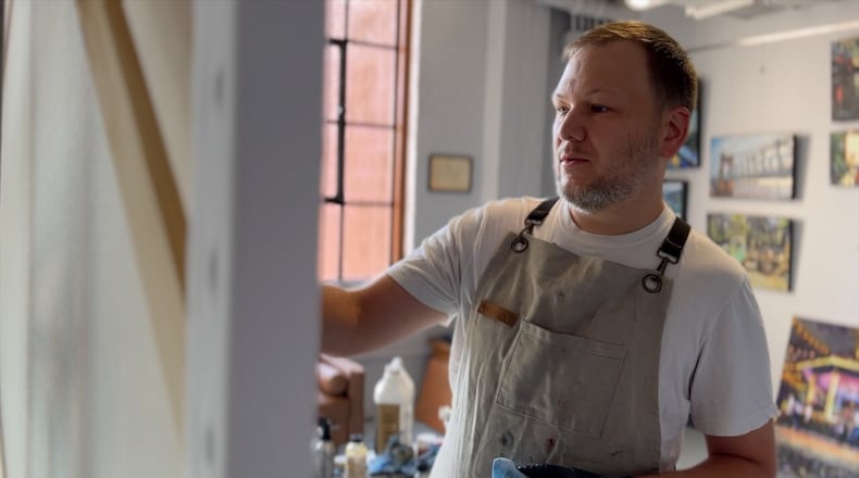 Artist Tony Lipps paints a picture of Cincinnati Bengals quarterback Joe Burrow. Lipps used to work as a corrections officer in the jail in Queensgate. Now, he paints full-time in a studio reimagined in the old jail building. KEITH BIERYGOLICK/WCPO