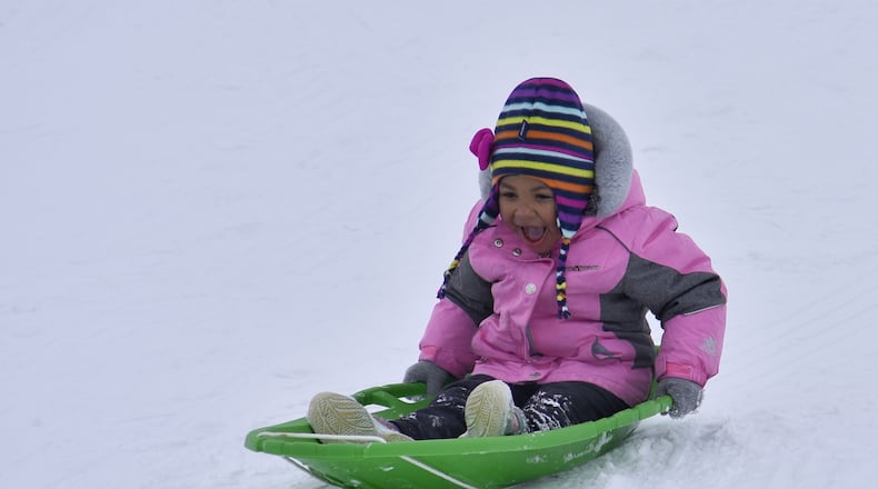 Alora Sheafe, 3, sleds down a hill at Voice of America MetroPark Thursday, February 18, 2021 in West Chester Township. Many schools in the area were off for a snow day. NICK GRAHAM / STAFF