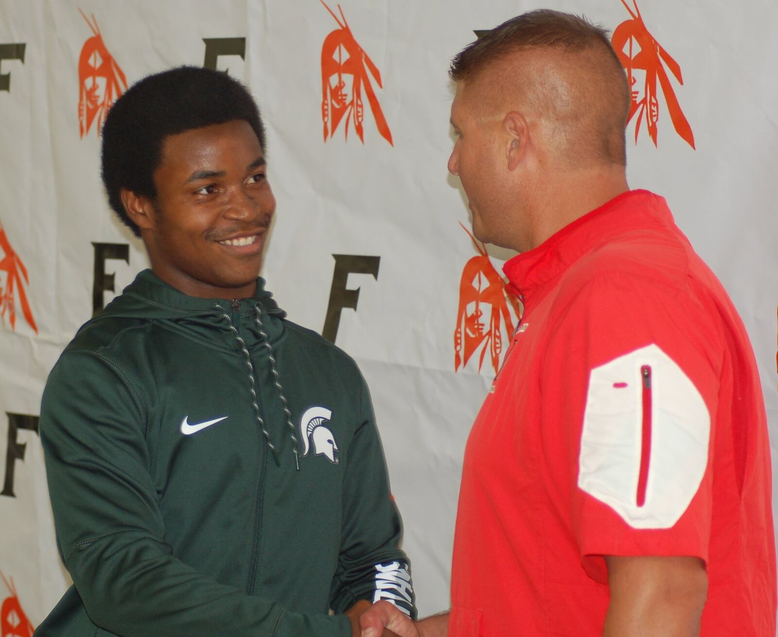 Fairfield defensive back Josiah Scott shakes hands with FHS coach Jason Krause after announcing his commitment to Michigan State University on July 31, 2016. CONTRIBUTED BY JOHN CUMMINGS