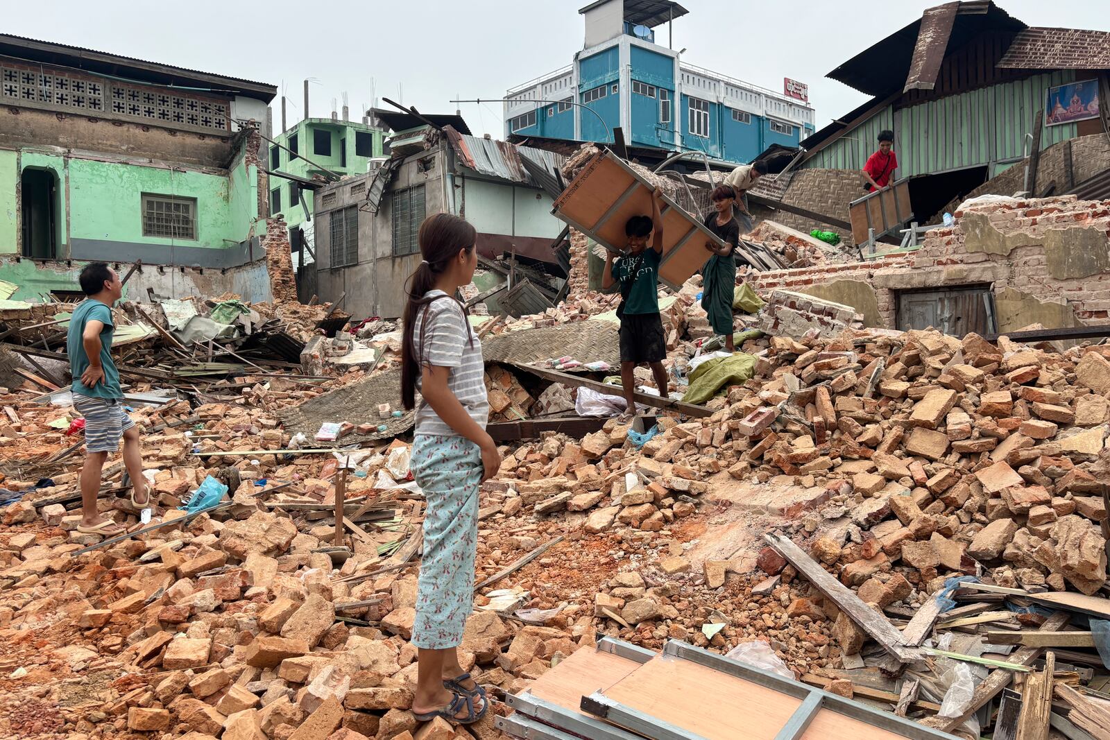 People clean debris from damaged buildings in the aftermath of an earthquake on March 28, in Naypyitaw, Myanmar, Monday, April 7, 2025. (AP Photo)