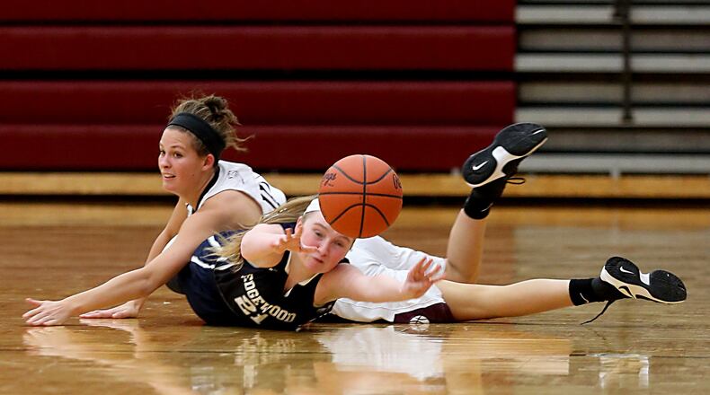 Edgewood guard Cierra Lipps passes to a teammate while underneath Lebanon guard Ashley West during their game at Lebanon on Monday night. CONTRIBUTED PHOTO BY E.L. HUBBARD