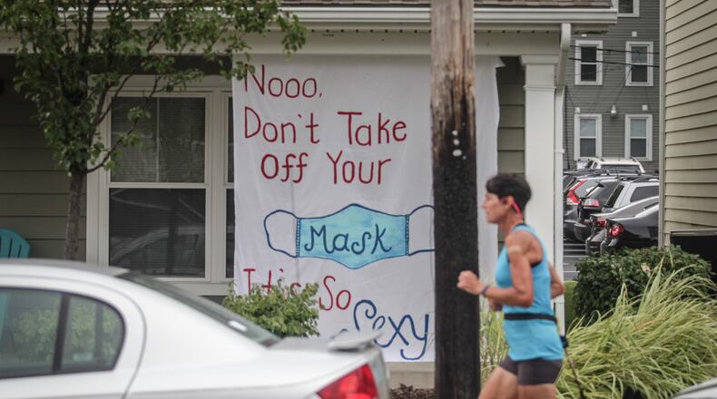 A jogger runs by UD housing that is sending a message to other students.