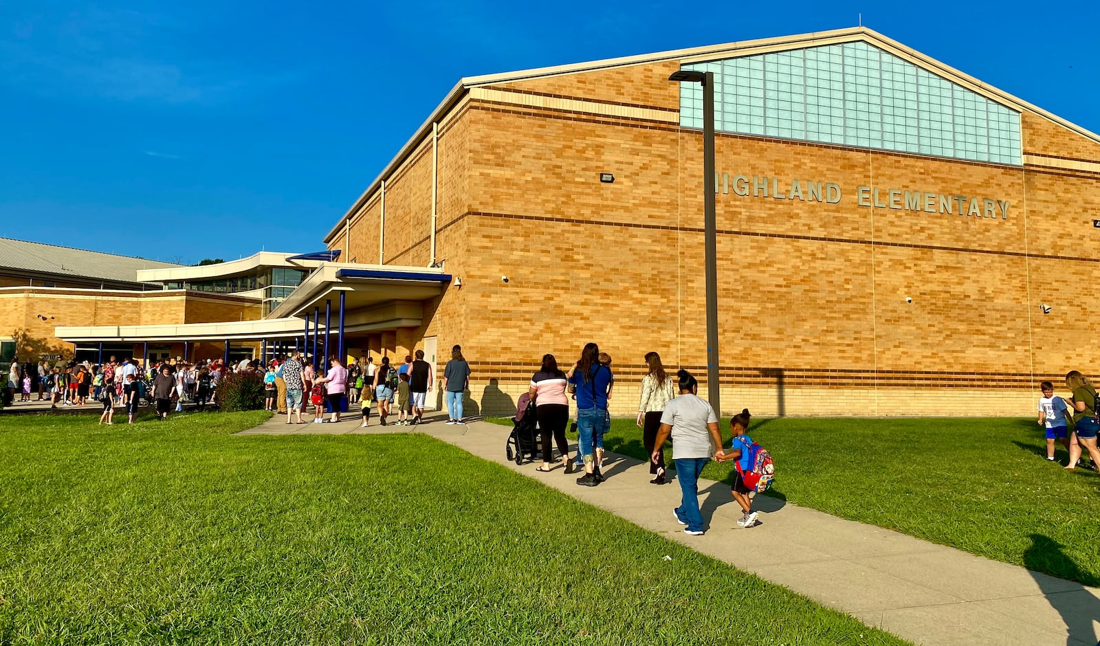 The second of Hamilton Schools’ two-day opening saw many school parents escorting their children to their city school buildings as classes are now at full capacity. More than 9,000 students filled Hamilton’s 12 public schools Tuesday in the Butler County seat city as some parents said they appreciated school system officials’ efforts to make the start of the new school year a smooth one. Pictured are parents escorting their children to Highland Elementary. (Photo By Michael D. Clark/Journal-News)