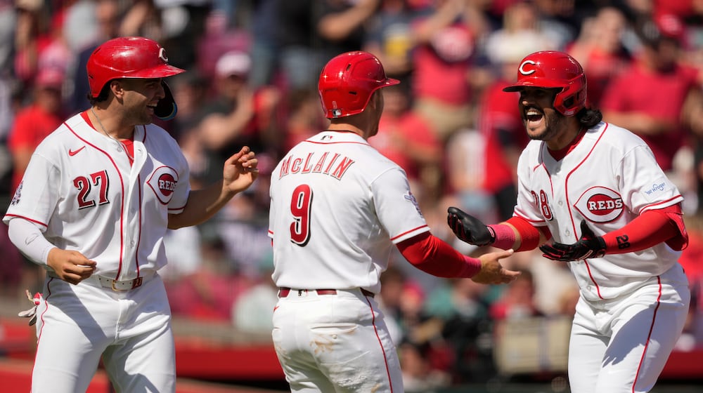 Cincinnati Reds' Eugenio Suárez (28), celebrates with Matt McLain (9) and Sal Stewart (27) after hitting a three-run homer during the sixth inning of a baseball game against the Boston Red Sox in Cincinnati, Sunday, March 29, 2026. (AP Photo/Carolyn Kaster)