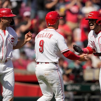 Cincinnati Reds' Eugenio Suárez (28), celebrates with Matt McLain (9) and Sal Stewart (27) after hitting a three-run homer during the sixth inning of a baseball game against the Boston Red Sox in Cincinnati, Sunday, March 29, 2026. (AP Photo/Carolyn Kaster)