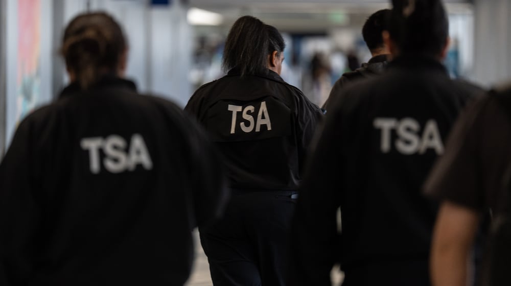 TSA agents walk through a terminal at Los Angeles International Airport in Los Angeles, Friday, March 27, 2026. (AP Photo/Jae C. Hong)